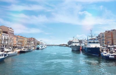 Boats moored in sea against buildings in city