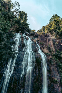 Scenic view of waterfall against sky