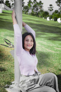 Portrait of a smiling young woman sitting on grass