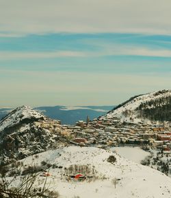 Aerial view of buildings by sea against sky