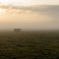 Scenic view of field against sky during foggy weather