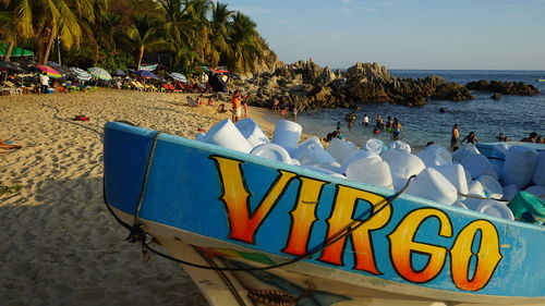 Deck chairs on beach against blue sky