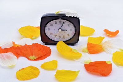 Close-up of clock on table against white background
