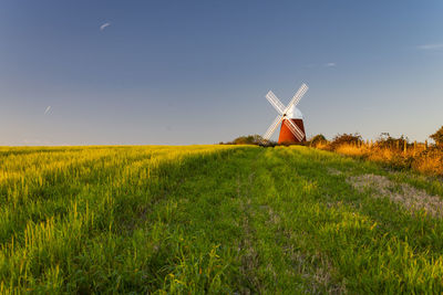 Traditional windmill on field against sky