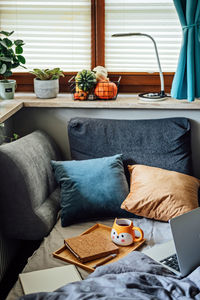 Cozy home, autumn warm mood. laptop, notebook and cup of tea at tray on blanket in bed in the