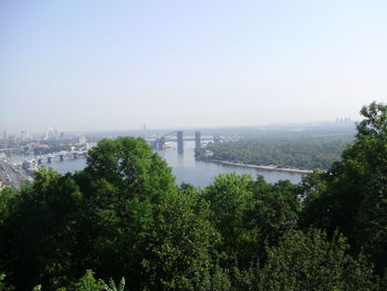 Scenic view of river by city against clear sky