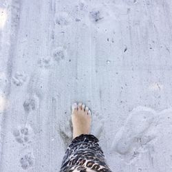 Low section of woman standing on sand