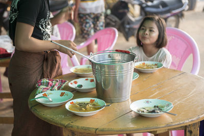 Man serving food to girl at table