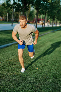 Full length of young man exercising on field