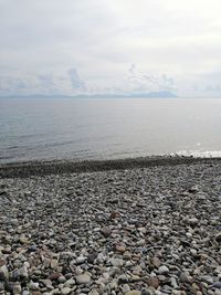 Stones on beach against sky