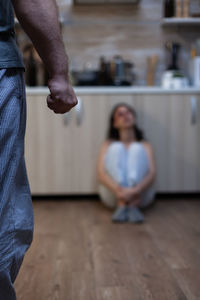 Midsection of couple sitting on floor