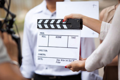 Cropped hands of woman holding film slate