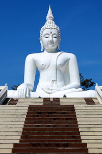 Low angle view of statue against building against sky