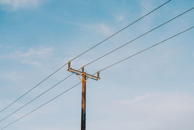 Low angle view of electricity pylon against sky