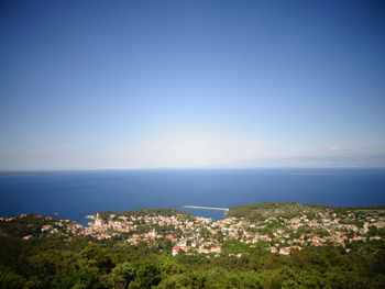 High angle view of cityscape by sea against clear sky