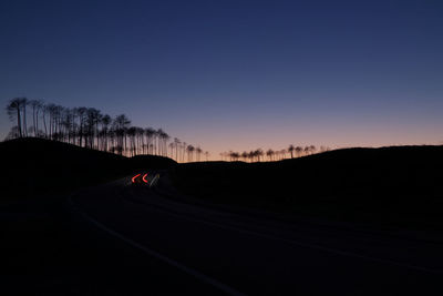 Silhouette of road against clear sky at sunset