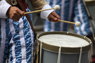 Midsection of man playing drum in city