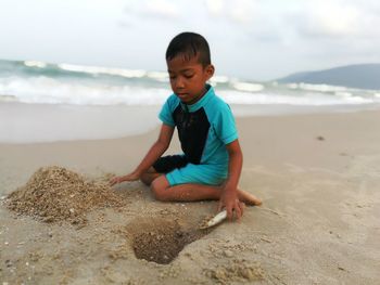 Boy playing on sand at beach