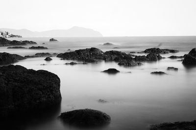 Rocks in sea against sky