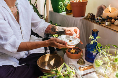 Midsection of aromatherapist holding crystal at spa