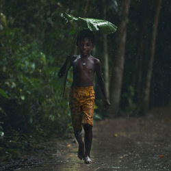 Portrait of young boy standing in water