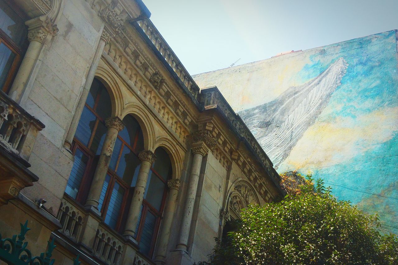 architecture, building exterior, built structure, low angle view, clear sky, sky, window, house, building, sunlight, blue, day, residential structure, residential building, outdoors, no people, mountain, history, church, religion