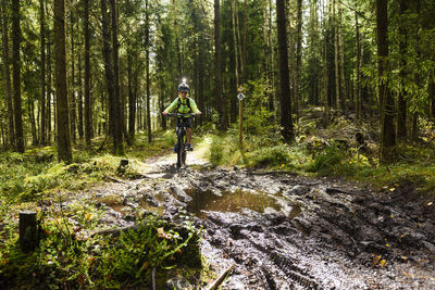 Boy cycling in forest