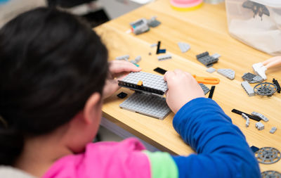 High angle view of girl playing with toy blocks on table