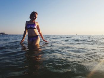 Woman in sea against clear sky