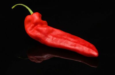 Close-up of red chili peppers against black background