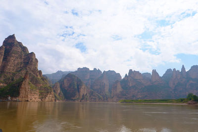 Scenic view of mountains against cloudy sky