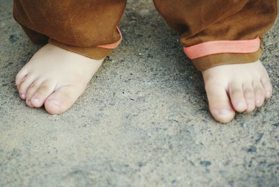 Low section of child standing on road