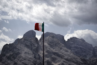 Low angle view of flag on mountain against sky