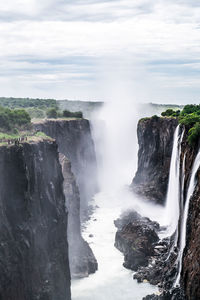 Scenic view of waterfall against sky