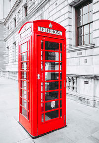 Red telephone booth on sidewalk