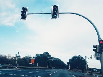 Road sign on street against sky