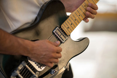 Midsection of man playing guitar