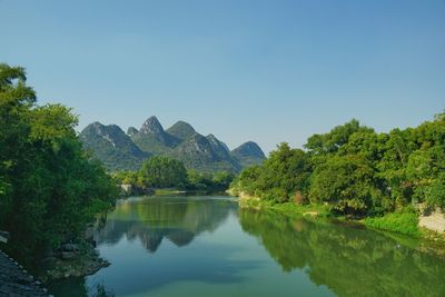 Scenic view of lake and mountains against clear sky