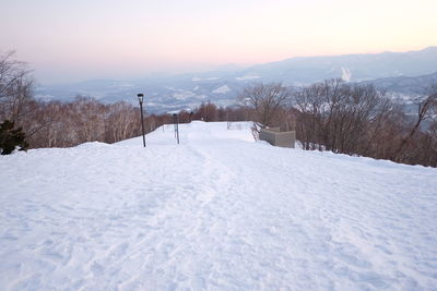 Snow covered land and mountains against sky