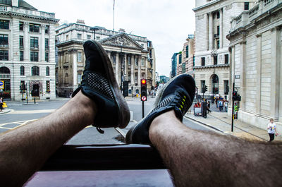 Midsection of man on street in city against sky