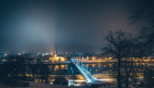 Illuminated city against sky at night