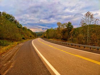 Road amidst trees against sky