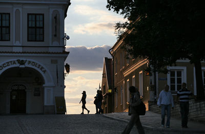 People walking in city against sky