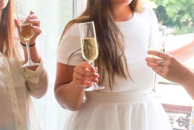 Close-up of young women drinking champagne