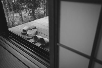 High angle view of footwear on porch seen through transparent door