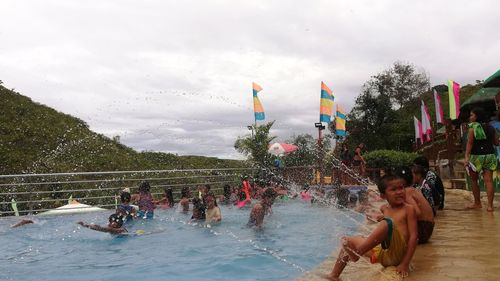 People in swimming pool against sky