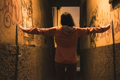 Rear view of woman standing in corridor