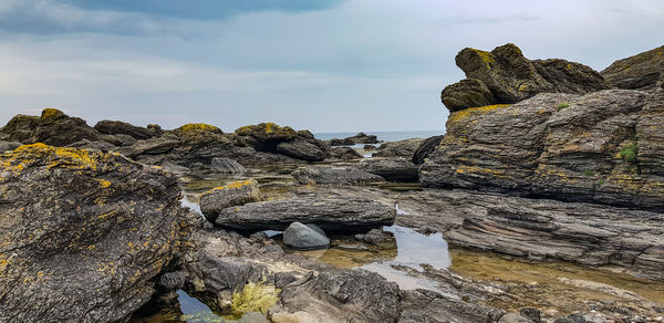 Rocks on beach against sky