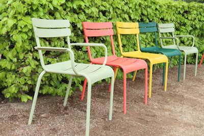 Empty chairs and table on field