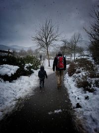 People walking on snow covered landscape during winter